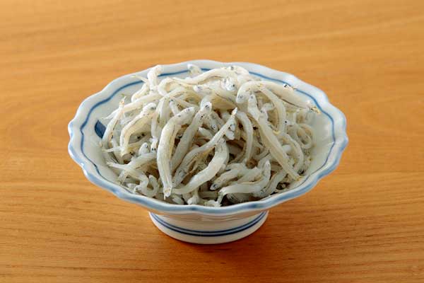 シラス干しを茶色の木目の板に置いて撮影