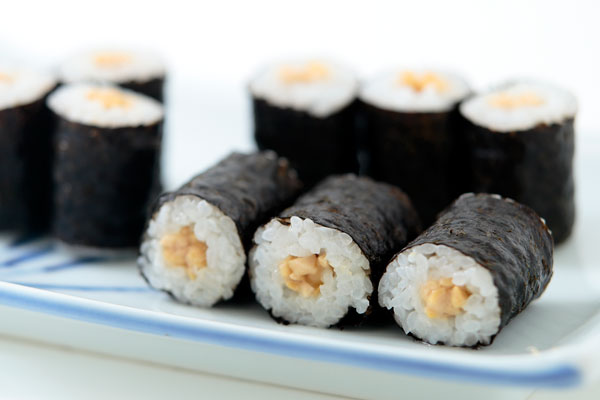納豆巻きの画像2点。皿に数巻の納豆巻きを盛りつけ、前列の数巻にだけピントを合わせたアップ画像。白いバック1カット