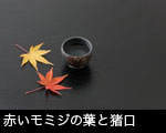 赤いモミジの葉と猪口