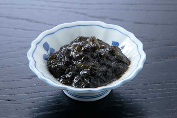 小鉢に盛りつけた海苔の佃煮の写真。つややかな質感、背景は黒い木目のお盆。フリー写真素材。